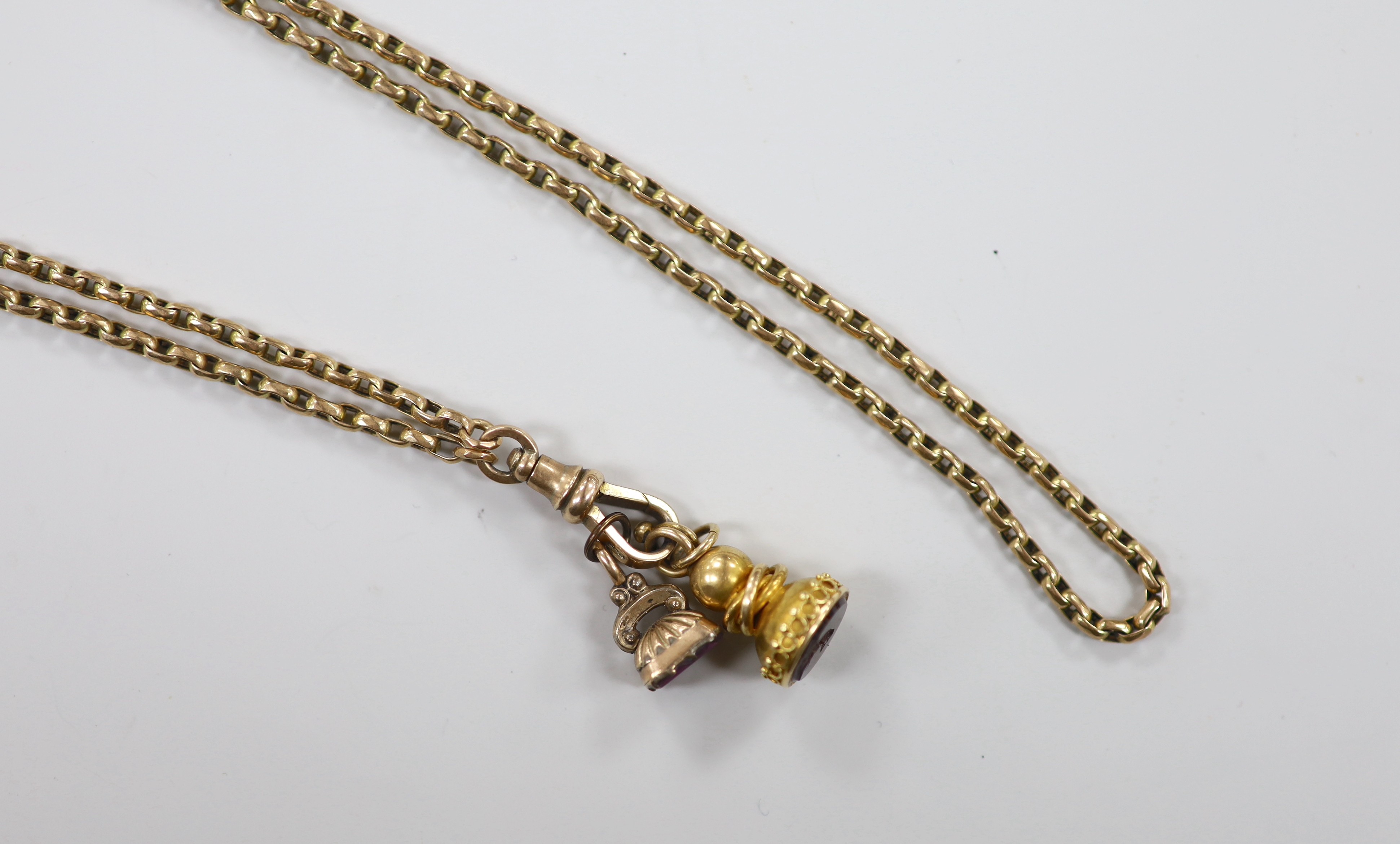 A late Victorian 9ct guard chain, hung with two yellow metal overlaid seals, with amethyst or red carnelian? carved matrices, chain length 164cm, 32.9 grams.